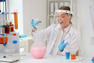 Female chemist conducting experiment at table in laboratory