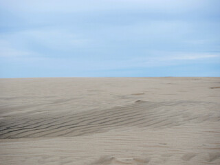 Rabjerg Mile - moving migrating coastal dune near Skagen, Denmark. Sand and sky. Abstract photo, divided in half into 2 parts 50-50 concept