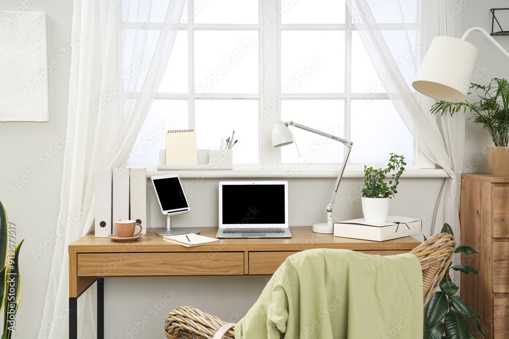 Wall mural modern workplace with laptop, tablet computer and plant in light office