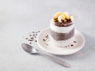 Chia pudding with raw coconut yogurt topped with cacao nibs and banana; copy space; plant-based diet