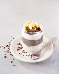Chia pudding with raw coconut yogurt topped with cacao nibs and banana; copy space; plant-based diet