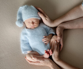 Newborn Baby Sleeps During A Photoshoot With Parents' Hands In The Frame