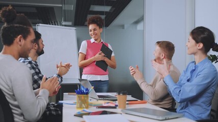 Diverse team of professionals applauding and showing appreciation for female colleague's presentation during office meeting. Concept of successful teamwork and collaborative spirit