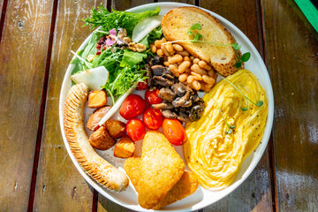 A cooked breakfast on a wooden table at a restaurant.