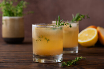 Pear lemonade with lemon, rosemary, thyme and ice on a wooden table. Healthy drink, sugar and alcohol free.