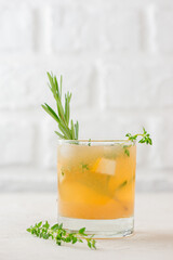Fresh cocktail with pear, ice and herbs on the light table. Vertical orientation.