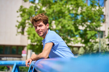 portrait of a man looking at a camera leaning against the camera