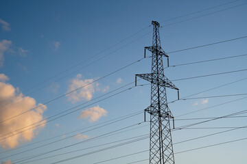Power lines with wires on blue sky with clouds