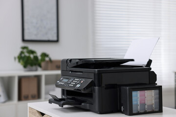 Modern printer with paper on table in office. Space for text