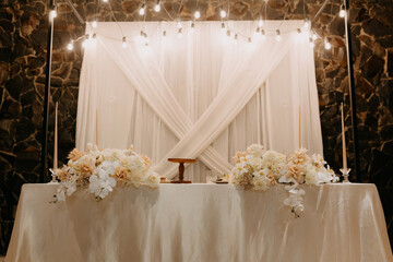 A stunningly decorated table for the newlyweds set within an elegant restaurant interior. The...