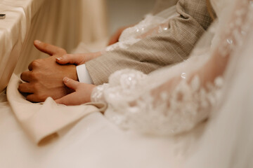 A touching photo of a married couple sitting at a table, holding hands. This image captures the intimacy and connection shared between the couple, highlighting their love and togetherness.