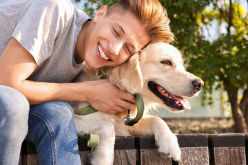 Portrait of happy owner with cute Golden Retriever dog outdoors on sunny day
