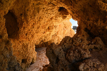 Beautiful red rocks cave with atlantic sea and beach in the Algarve on vacation in Portugal, Europe.