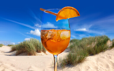 A cocktail with ice cubes and orange at the summer beach bar, by the sea on vacation, sizzling cool...