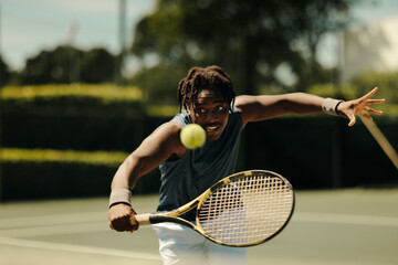 Focused tennis player volleying during an intense action-packed game on an outdoor court