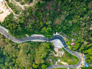 Aerial view of mountain road in forest in summer season, Top view from drone of curve road, Landscape with curved roadway, Beautiful trees Travel asia Phuket Thailand