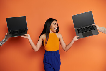 A confident woman showcases her multitasking skills with laptops in each hand.