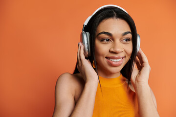 Delightful woman with headphones smiling while listening to her favorite tunes.