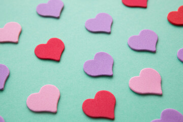 Fototapeta premium Pink and purple hearts on green background, love and relationship design element