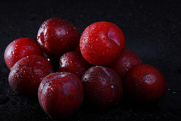 fresh plucked plum is cut into two halves	
