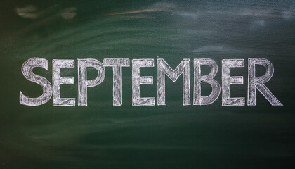 Word SEPTEMBER written in chalk on chalkboard. Start of back to school season.