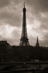 Obraz premium Sepia-toned photograph of the Eiffel Tower with a cloudy sky in Paris, France