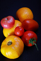 fresh ripe tomatos with water drops in studio on a black background	
