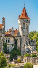 Obraz premium A majestic castle with a tall tower and vibrant gardens, showcasing architectural beauty in bright daylight