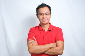 Close-up Portrait of young asian man smiling and wearing red shirt and glasses isolated on white background.