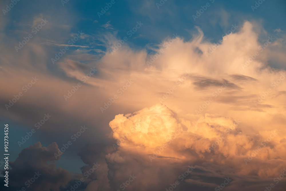 Poster Beautiful white clouds lighten with sun rays on the blue sky. Big clouds floating in the sky, forming together tino interesting shapes