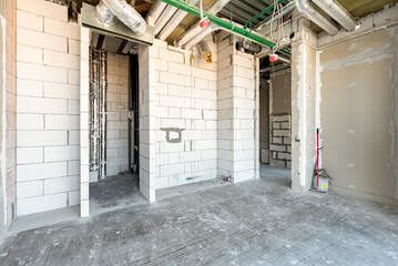 Built structure construction site of residential apartment building. Interior in progress to new house white brick wall