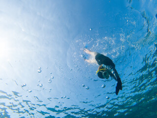 Obraz premium A person is swimming in the ocean with a yellow snorkel