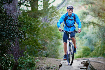 Fototapeta premium Man, bike and mountain path for training in outdoor, performance and extreme sports. Male person, athlete and workout in nature for triathlon, forest and riding exercise for fitness challenge