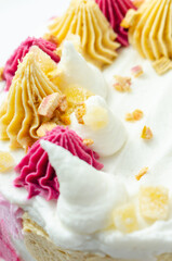 A cake with pink frosting and white frosting with a pink swirl on top