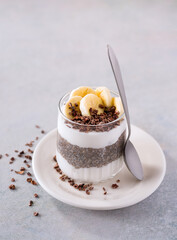 Chia pudding with raw coconut yogurt topped with cacao nibs and banana; copy space; plant-based diet
