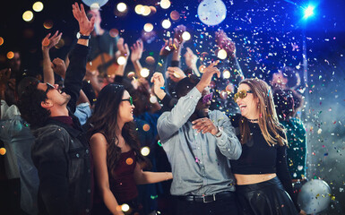 Confetti, people and dance at festival for New Year celebration with smile and fun at nightclub. Music, disco lights and excited for concert with entertainment for memories, break and enjoy party