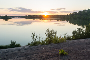 Sunset on the lake, and yellow leaves of trees. Natural autumn background.