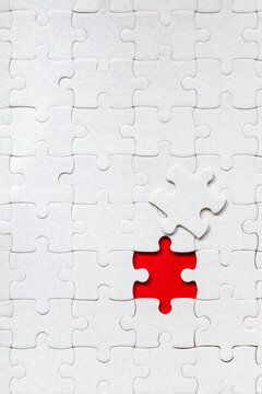 White jigsaw puzzle. White puzzle pieces on color background. Unfinished white jigsaw puzzle pieces on color background.
