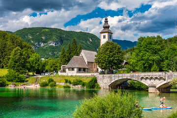 Aerial view of Bohinj lake in Julian Alps. Popular touristic destination in Slovenia. Bohinj Lake, Church of St John the Baptist. Triglav National Park, Julian Alps, Slovenia.