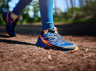 Person, shoes and walking in forest for exercise with strong body, wellness and outdoor sports....