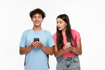 Surprised girl high school pupil student holding smart cell phone looking on mobile screen to her classmates boy boyfriend. Teenagers friends using phone app isolated on white background