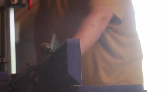 man sawing wood on a jointer in a home workshop