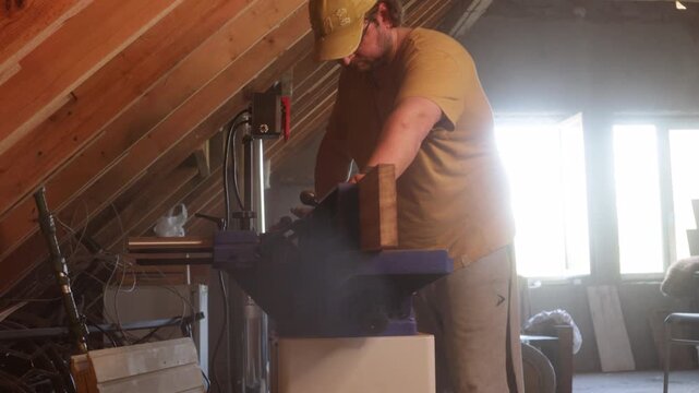 man sawing wood on a jointer in a home workshop