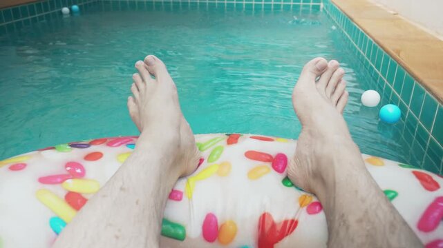 A donut float in a pool with sprinkles. The sprinkles are in different colors and sizes