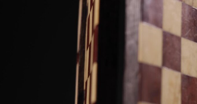 Detailaufnahme Rotation eines Backgammon und Schach Spielbretts vor schwarzem Hintergrund