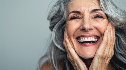 Elder lady laughing with hands on her cheeks, cheerful.