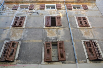 A large structure featuring numerous windows and shutters adorning it