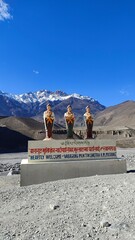 A buddhist monument with three monks in front of the himalaya mountains