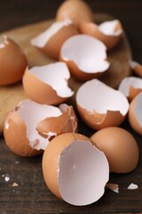 Pieces of broken eggshells on wooden table, closeup