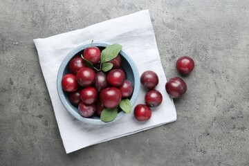 Fresh plums on grey textured table, flat lay © New Africa